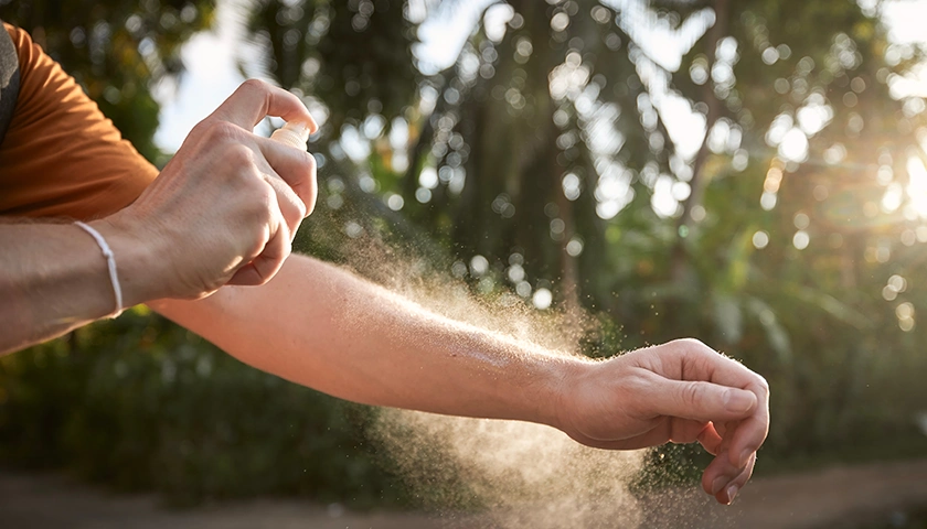 Hombre echándose repelente de insectos para prevenir las picaduras de mosquitos en verano. con aposán previenes picaduras